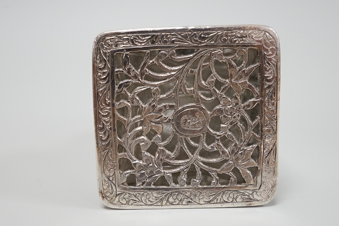 A Persian pierced white metal overlaid moulded glass salts bottle with stopper, decorated with urns and birds amid scrolling foliage, overall height 94mm.